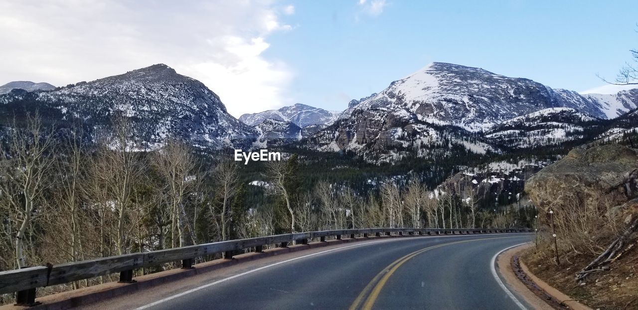 ROAD LEADING TOWARDS SNOWCAPPED MOUNTAINS AGAINST SKY