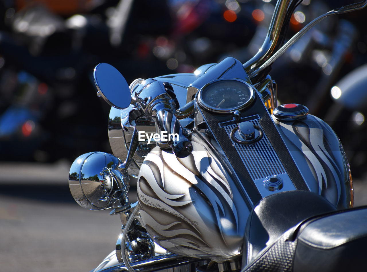 CLOSE-UP OF MOTORCYCLE AGAINST STREET