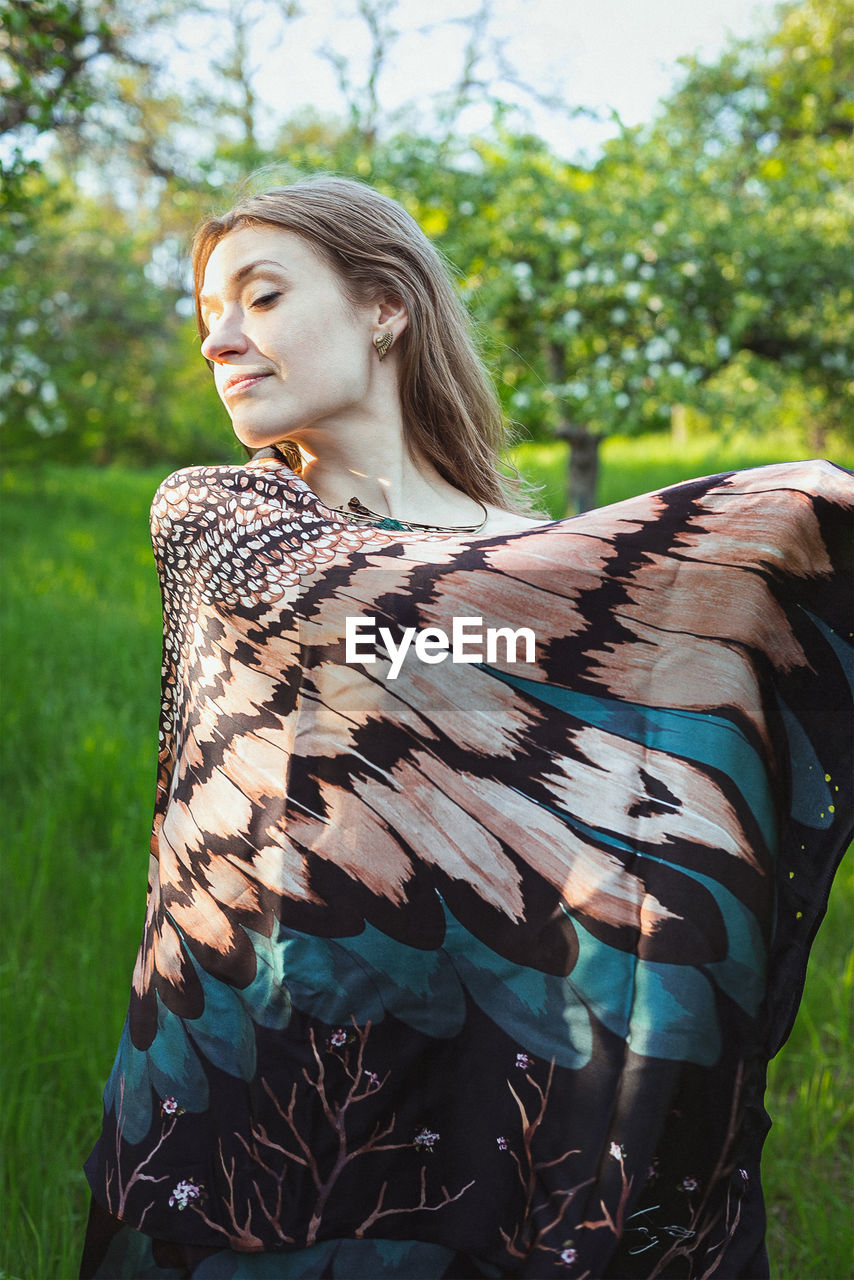 Woman covering shoulders with feathered wing shawl scenic photography