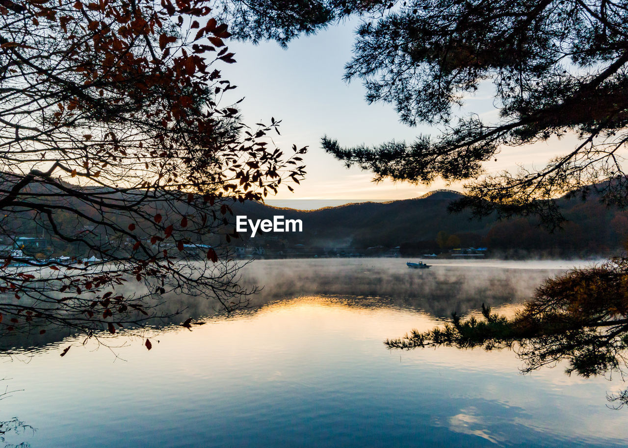 Scenic view of lake against sky at sunset