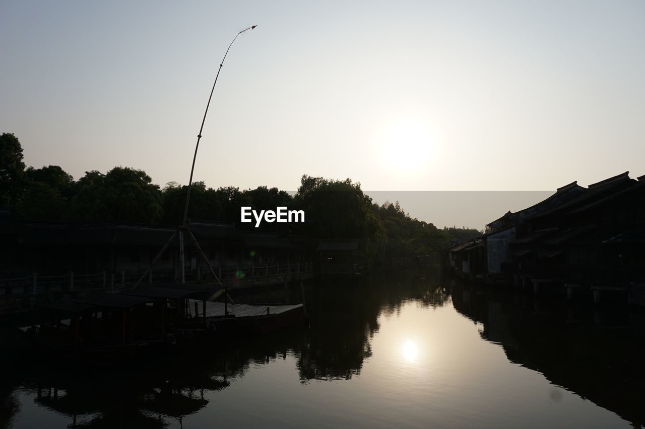 Silhouette of houses by river