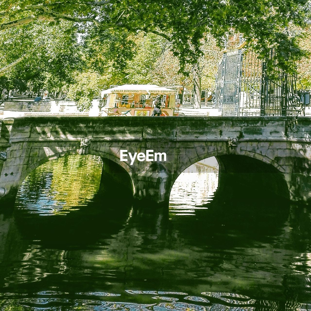 ARCH BRIDGE OVER RIVER AGAINST TREE