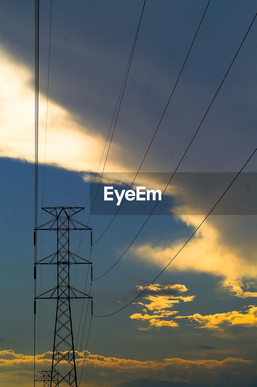 Low angle view of silhouette electricity pylon against sky during sunset