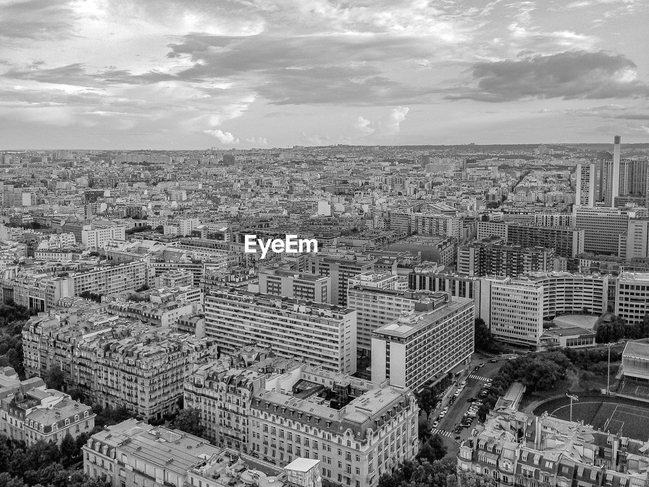 High angle view of city buildings against cloudy sky