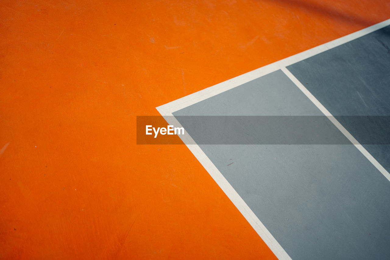 High angle view of empty chair against orange wall