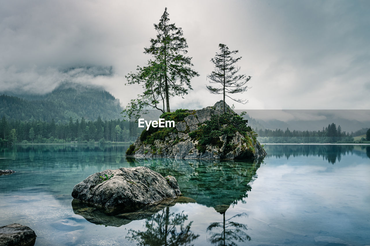 Cloudy sky over foggy mountains and lake, hintersee, ramsau, bavaria, germany