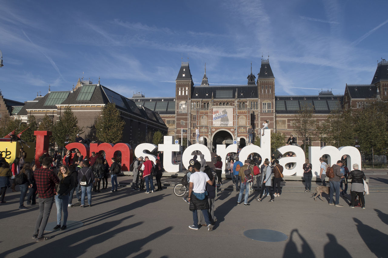 GROUP OF PEOPLE IN FRONT OF BUILDINGS