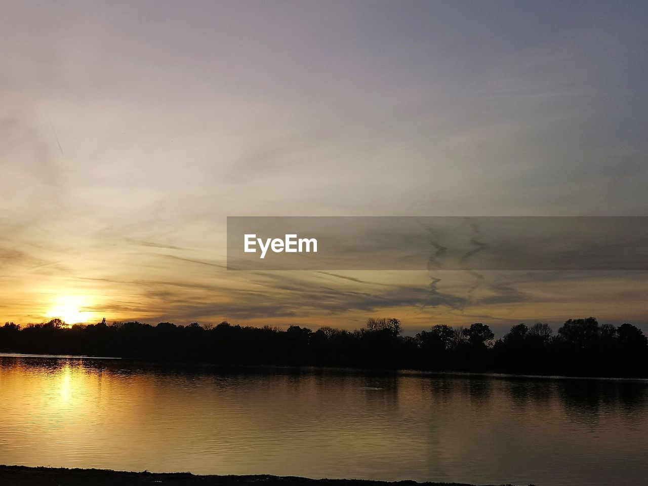 Scenic view of lake against sky during sunset