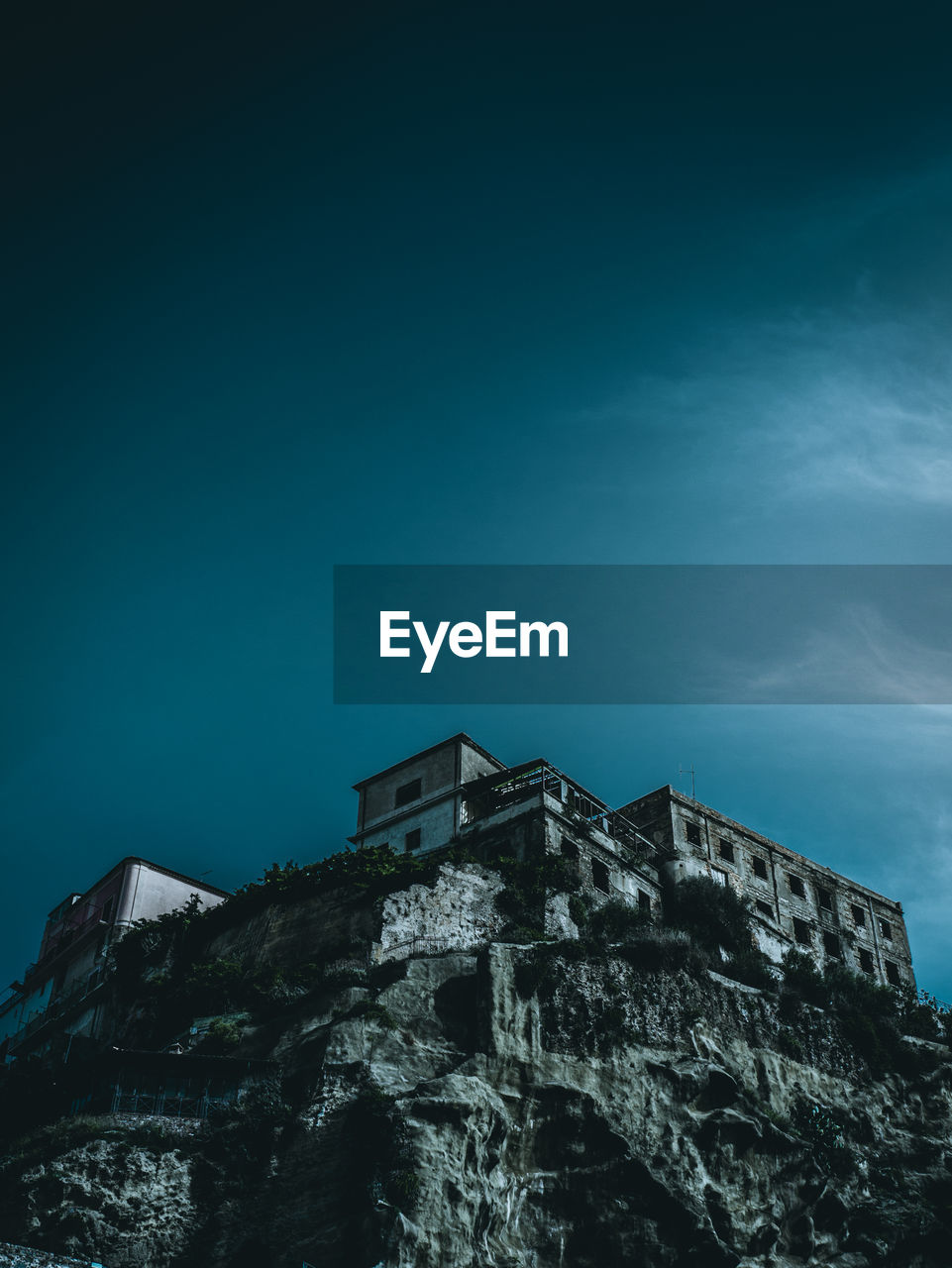 LOW ANGLE VIEW OF ABANDONED BUILDING AGAINST MOUNTAIN