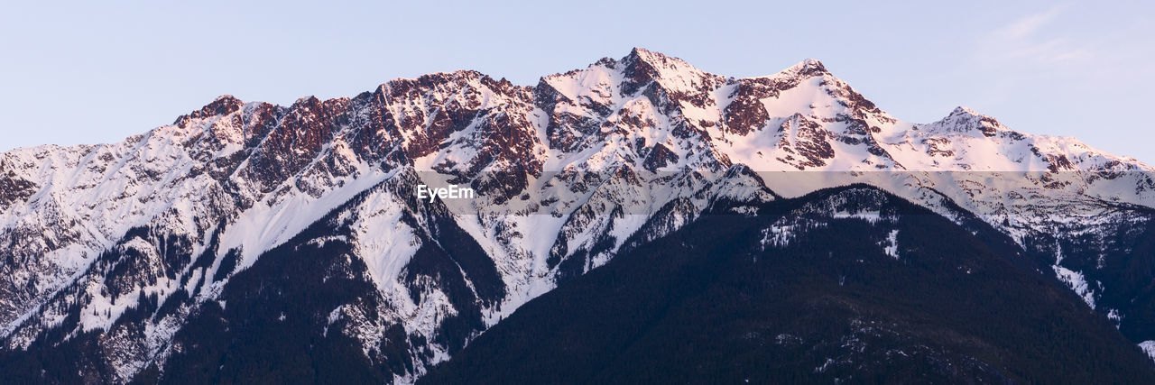 The sun sets on iconic mount currie still covered in snow on a spring day in the coast mountains of british columbia.