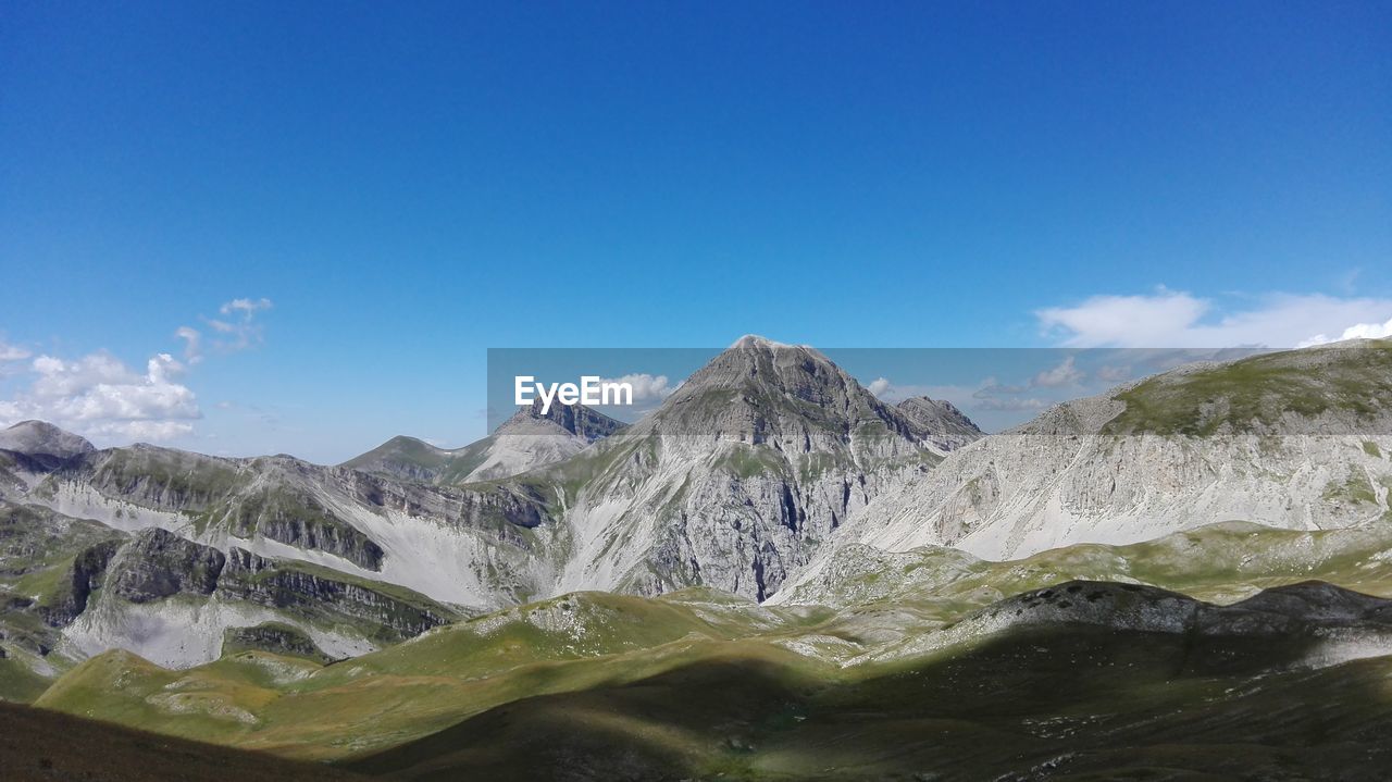 Scenic view of mountain range against cloudy sky