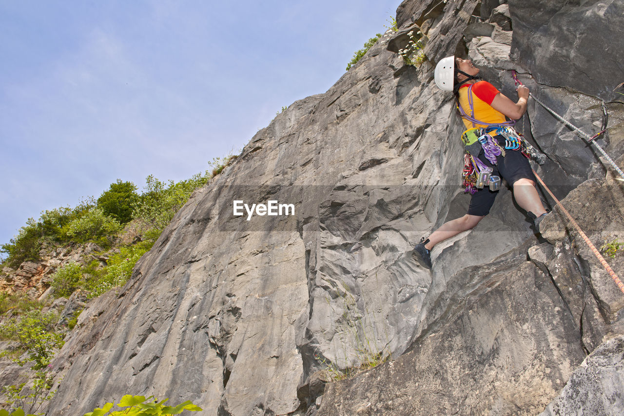Woman climbing limestone cliff in south wales