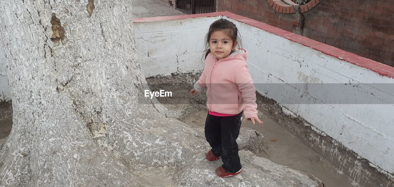 FULL LENGTH PORTRAIT OF CUTE GIRL STANDING ON FLOOR