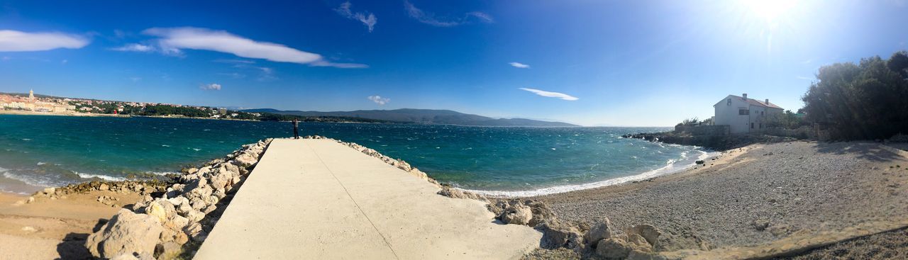 Panoramic view of beach against blue sky