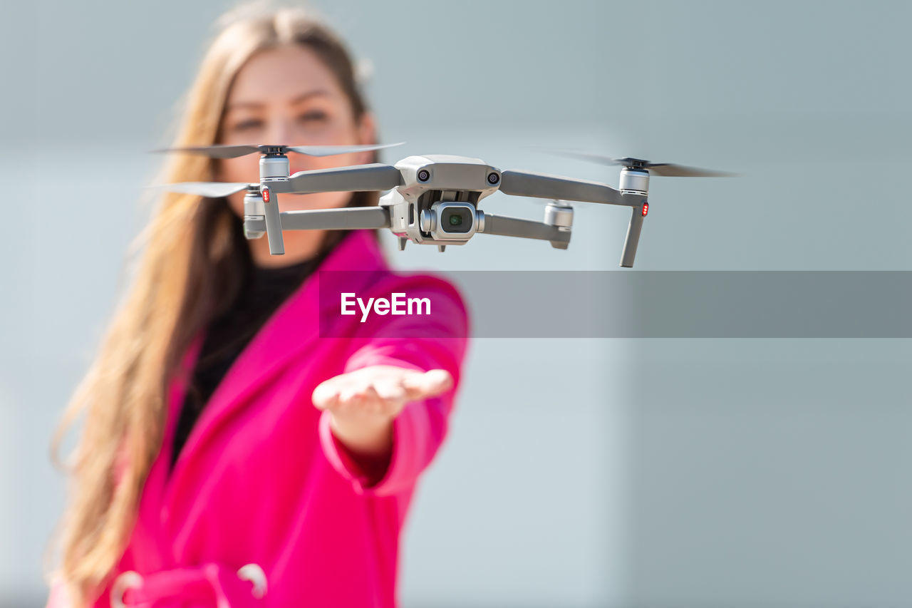 Close-up of drone while woman standing in background