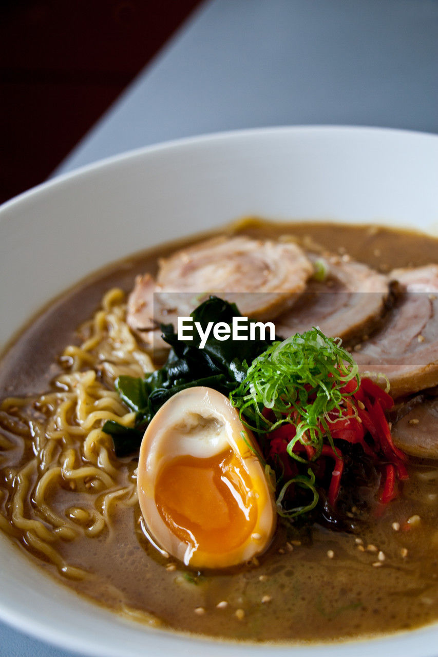 Close-up of tonkotsu ramen soup with runny egg