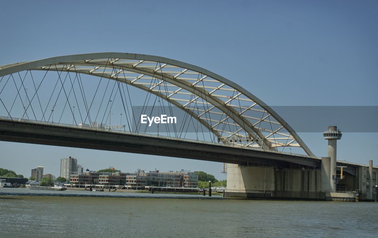 BRIDGE OVER RIVER IN CITY AGAINST SKY