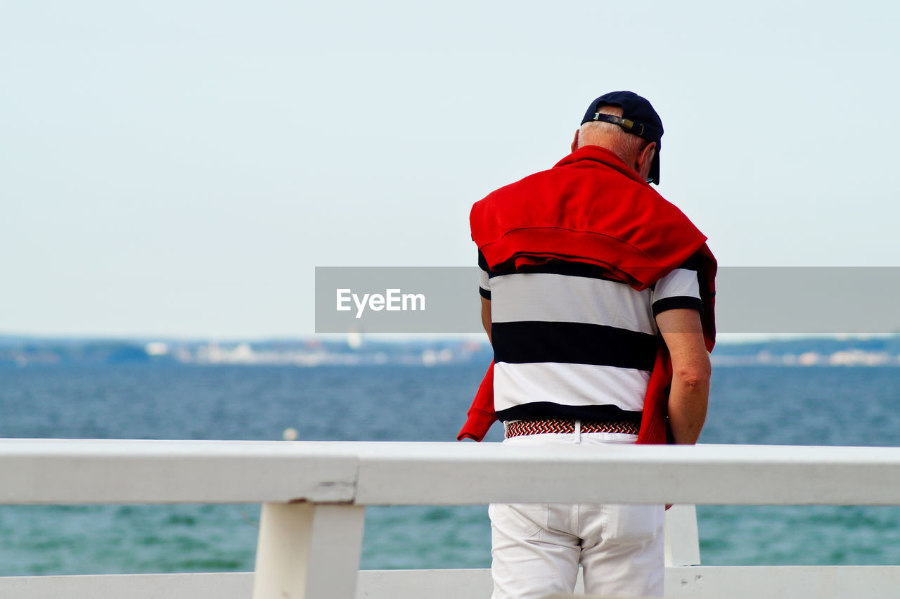 Rear view of a man overlooking calm lake