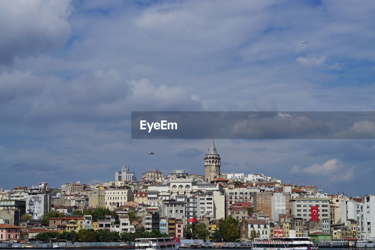 Low angle view of residential district against cloudy sky