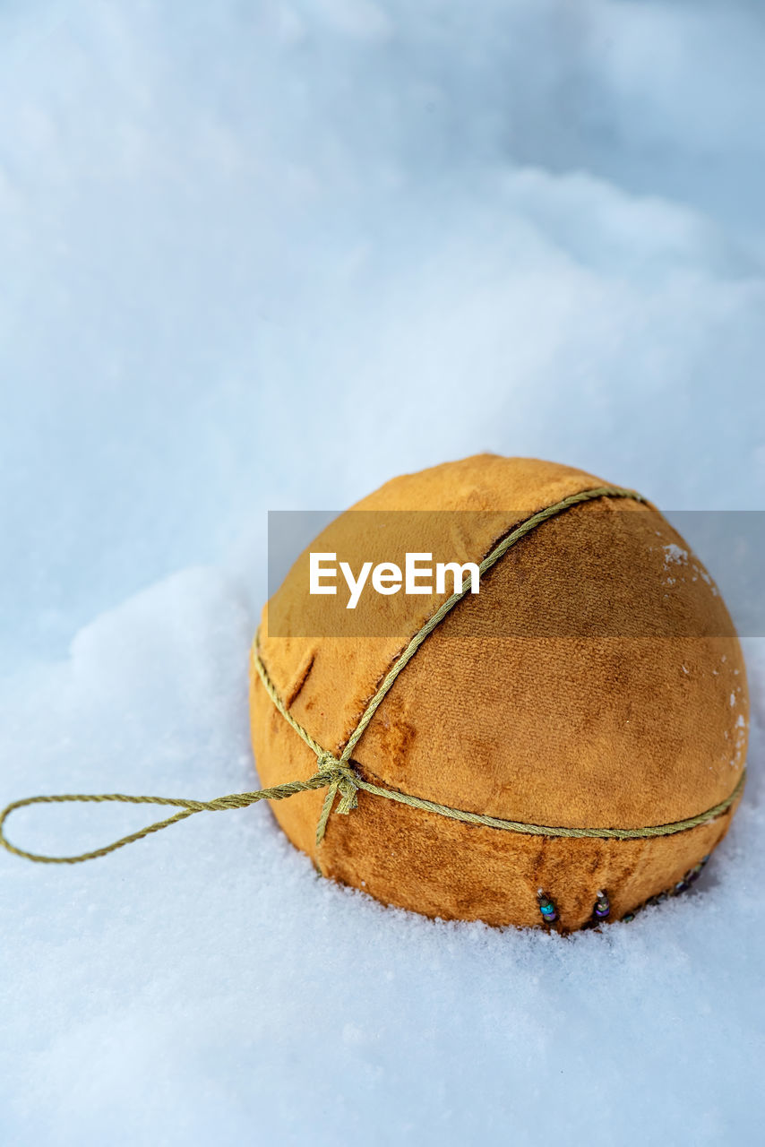 Orange christmas ball on the snow with copy space