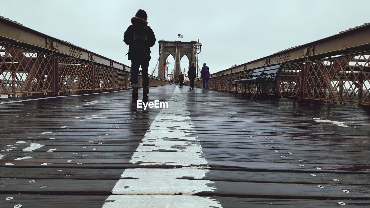 People on brooklyn bridge in city