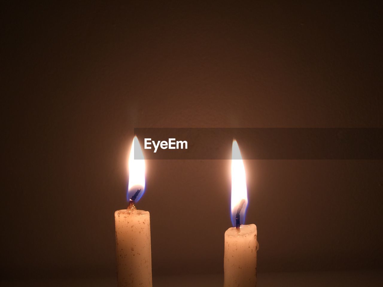 Close-up of burning candles in darkroom