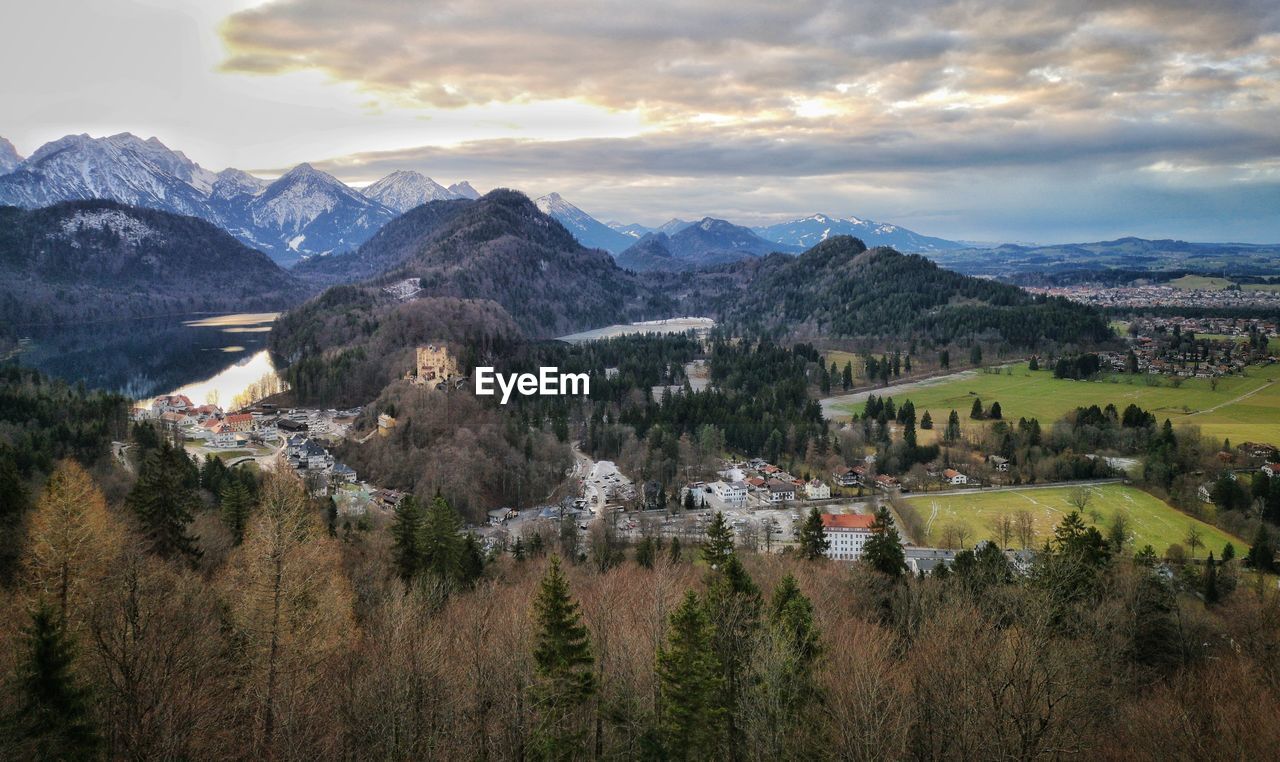 Scenic view of townscape by mountains against sky