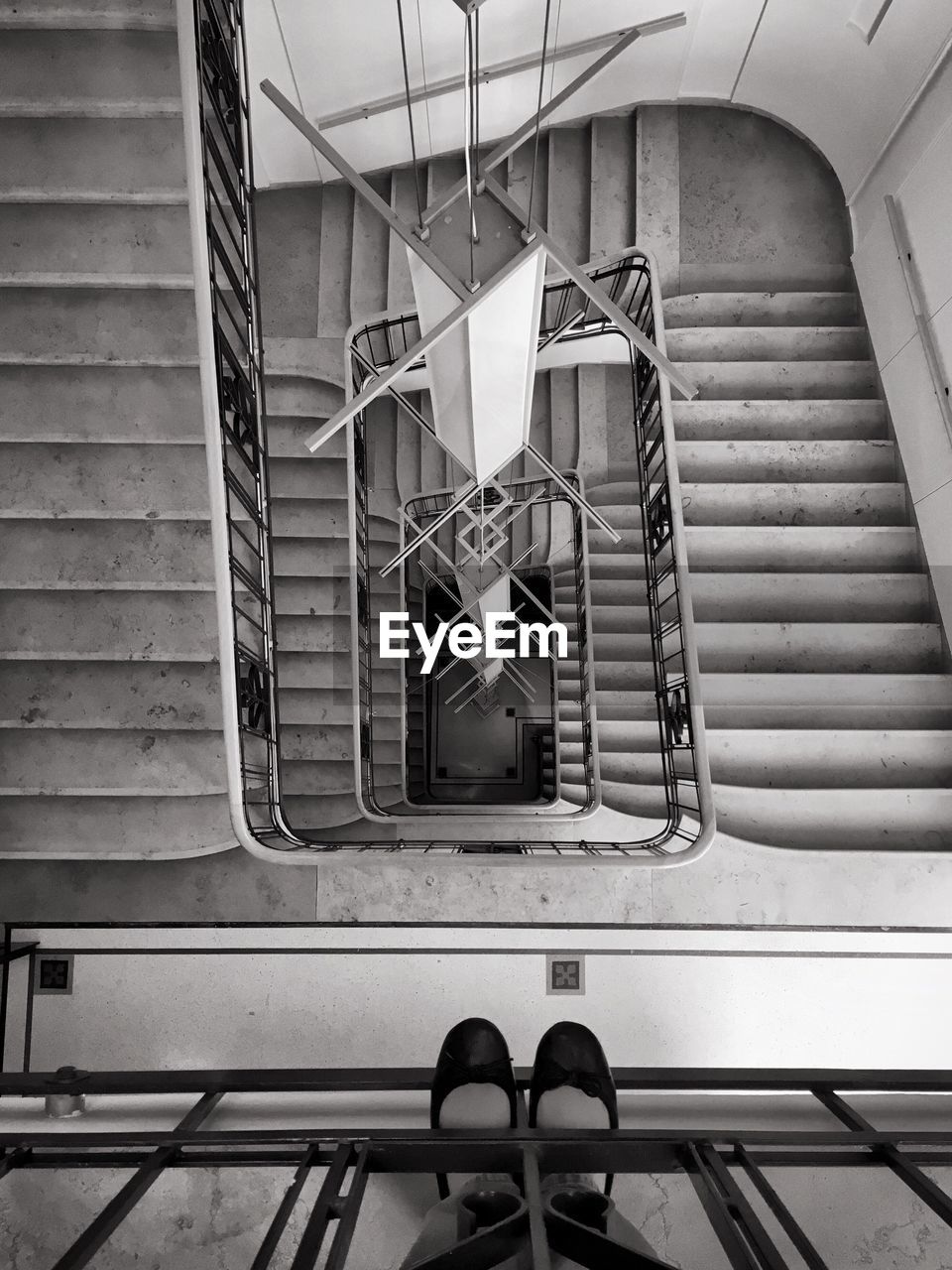 Low section of woman standing on railing against staircase