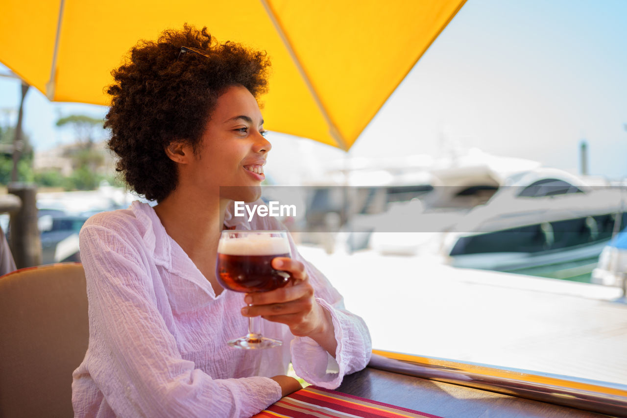 young woman using mobile phone while sitting on table