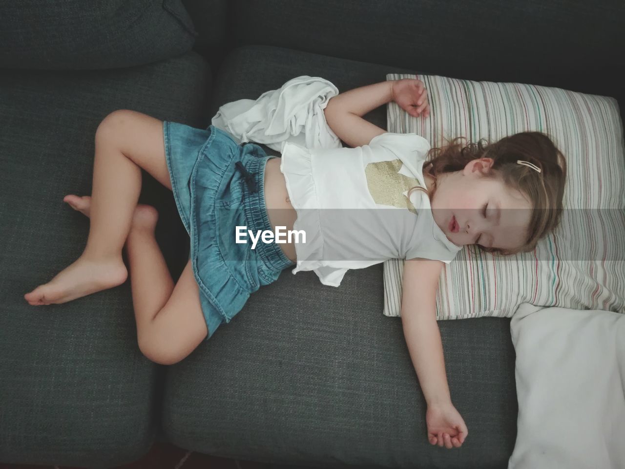 High angle view of girl sleeping on sofa at home