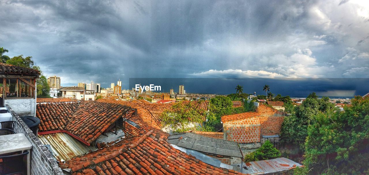 Panoramic view of cityscape against storm clouds