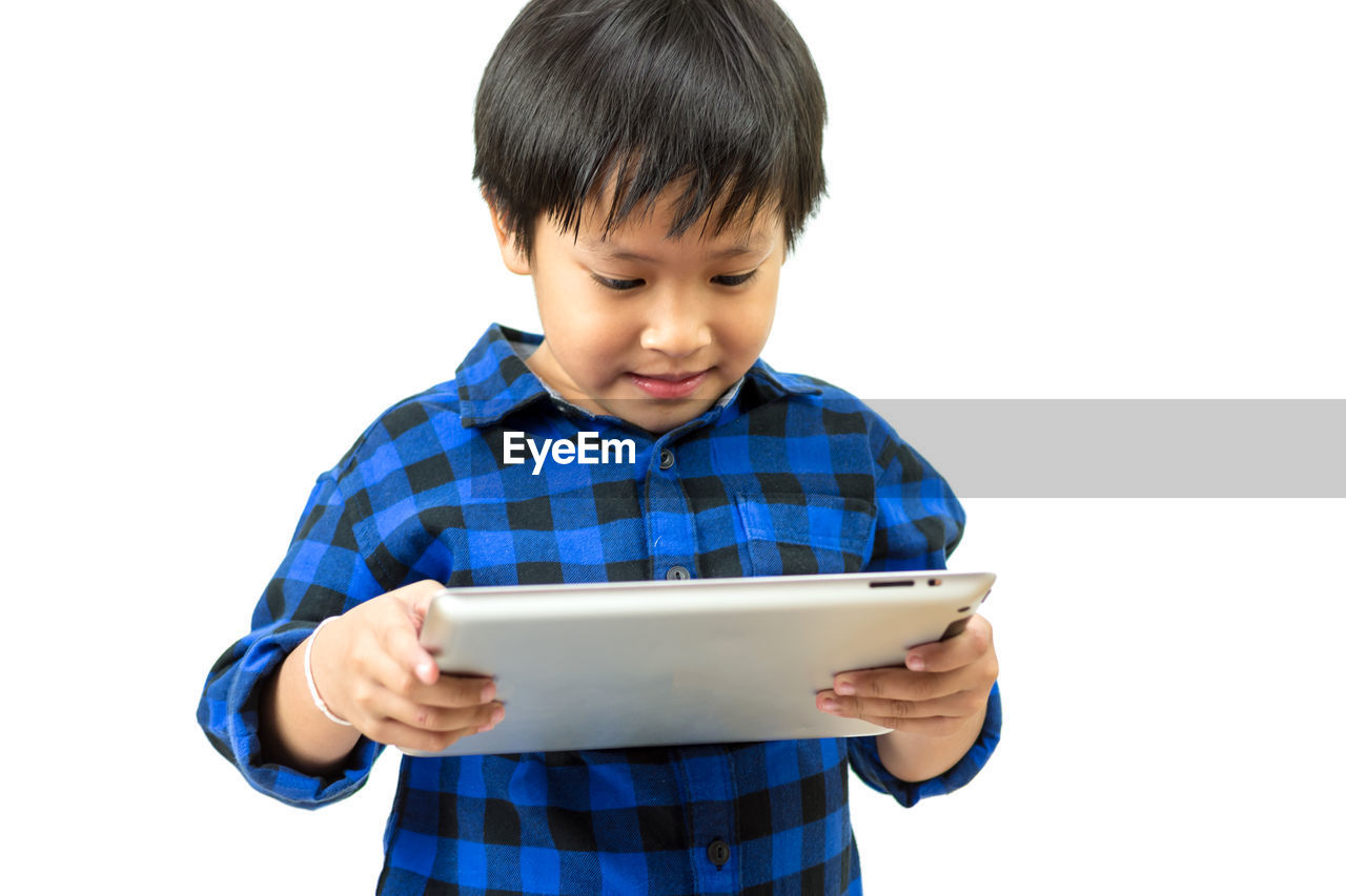 Boy using digital tablet against white background