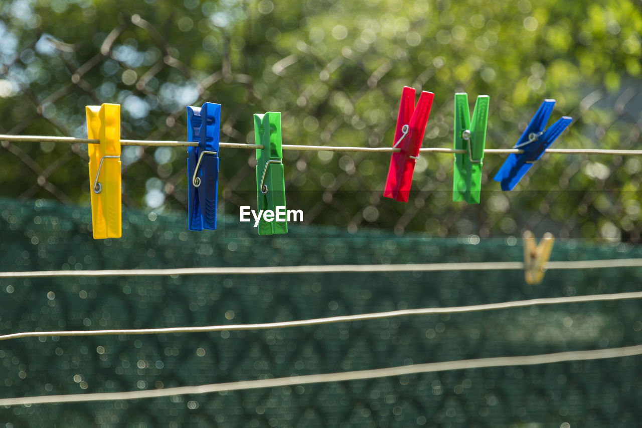 Close-up of colorful clothespin on string in back yard