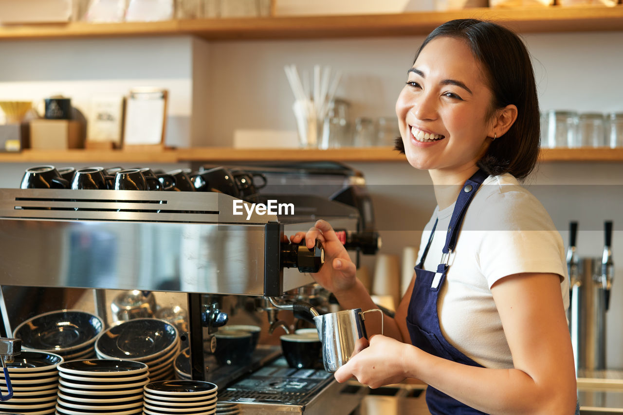 portrait of young woman holding coffee at home