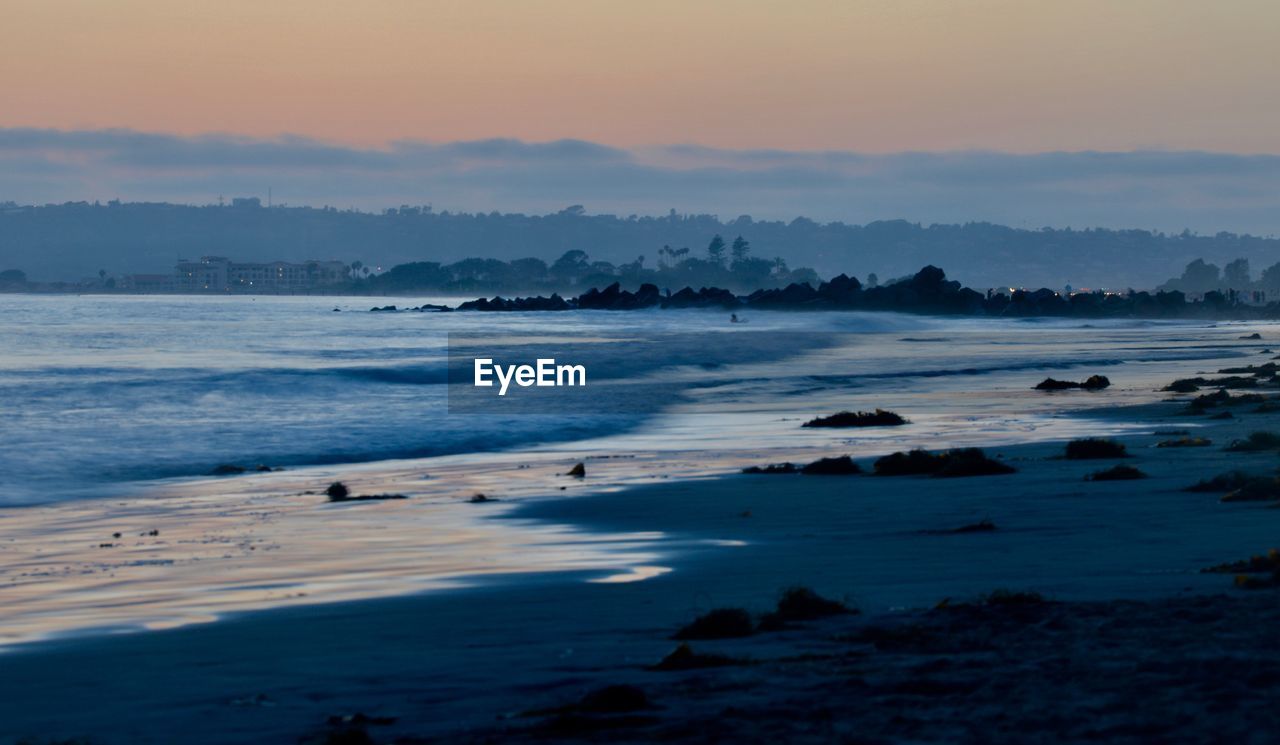 Scenic view of beach against sky during sunset