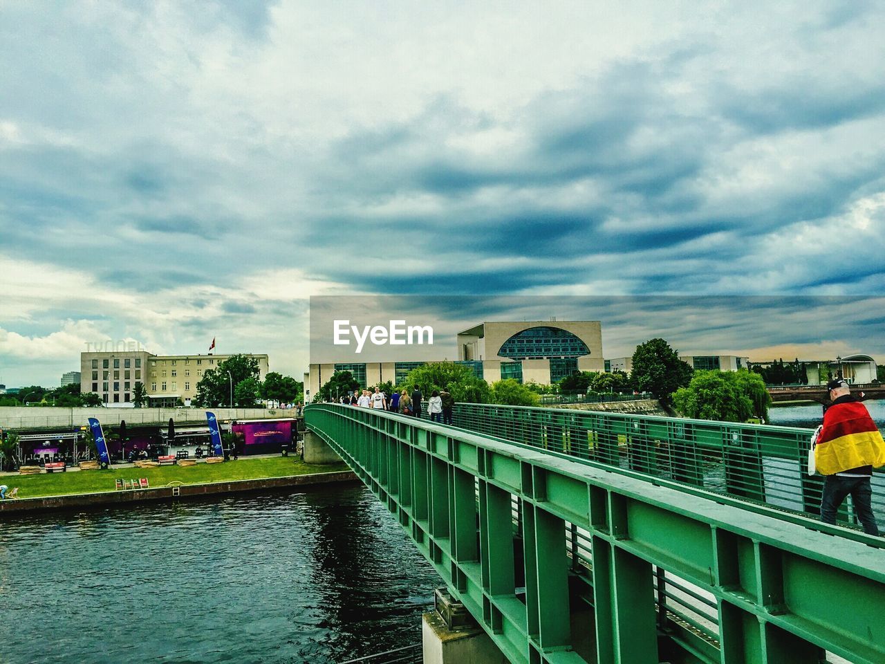 View of canal and buildings against cloudy sky