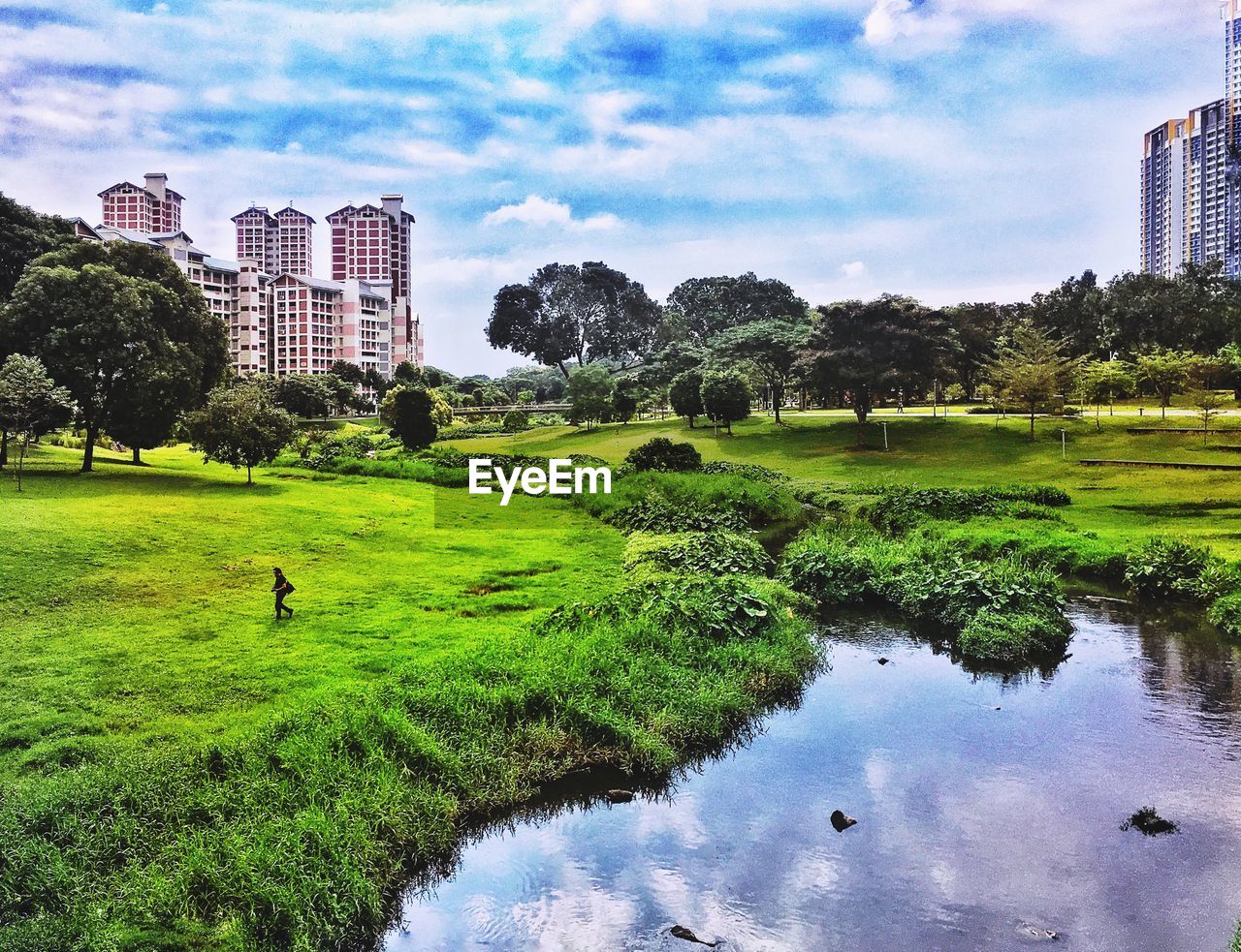 Scenic view of lake against sky in city