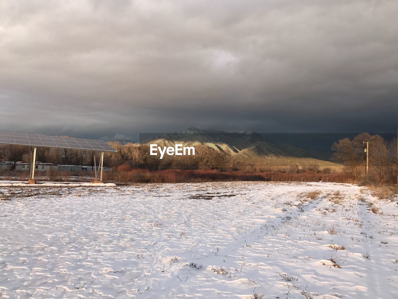 VIEW OF FROZEN LAKE AGAINST CLOUDY SKY