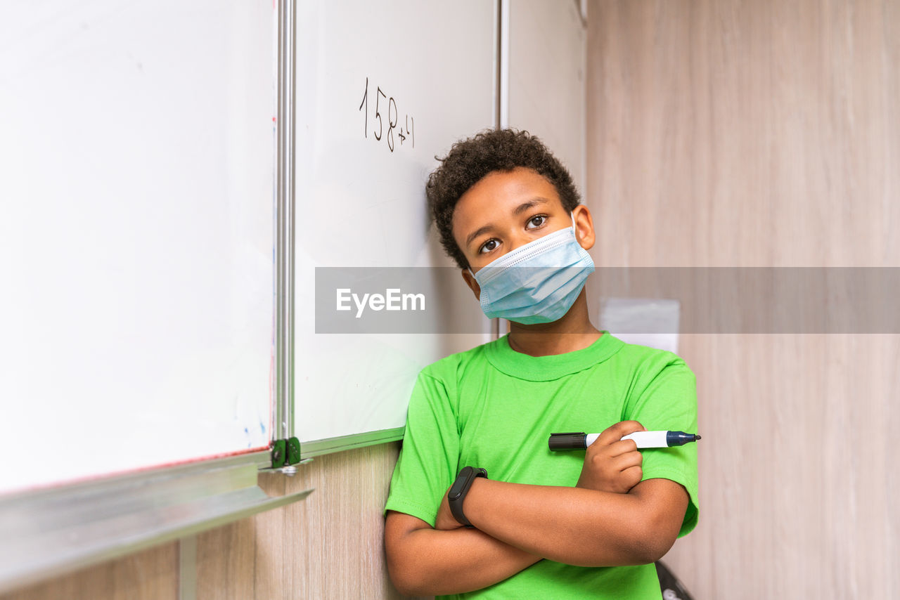 Cute boy standing by whiteboard