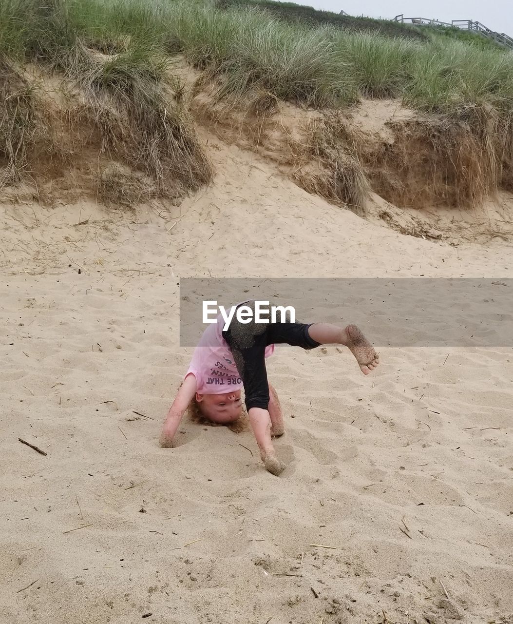 High angle view of girl doing headstand at beach