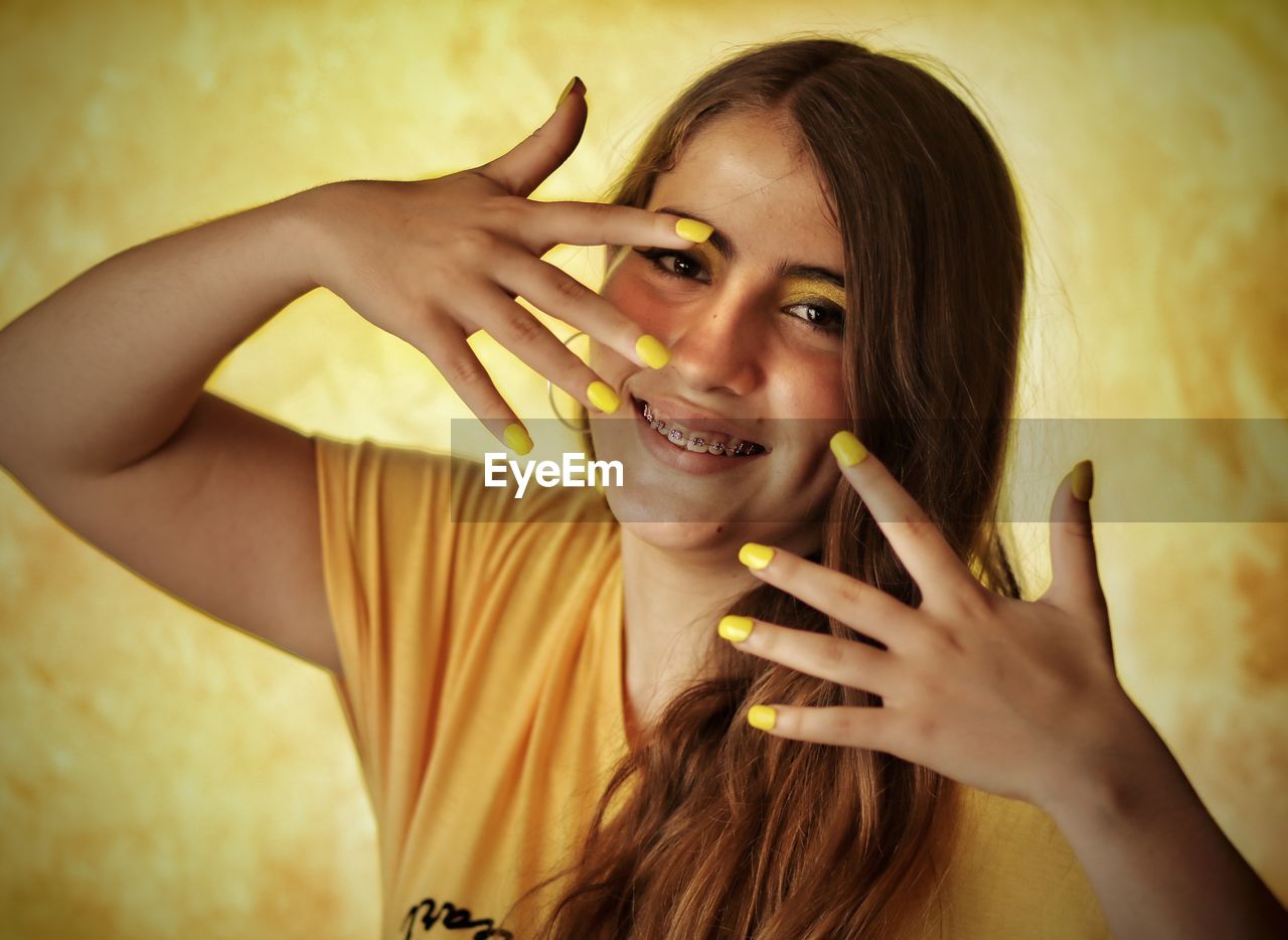 Portrait of girl with yellow nail paint