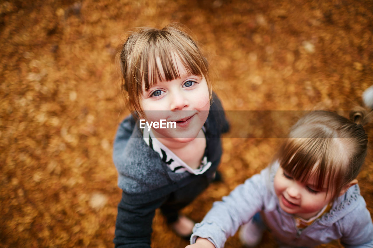 High angle view of siblings standing at park during autumn