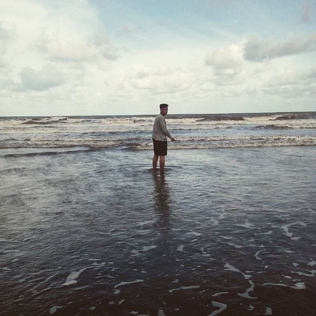 WOMAN STANDING ON BEACH