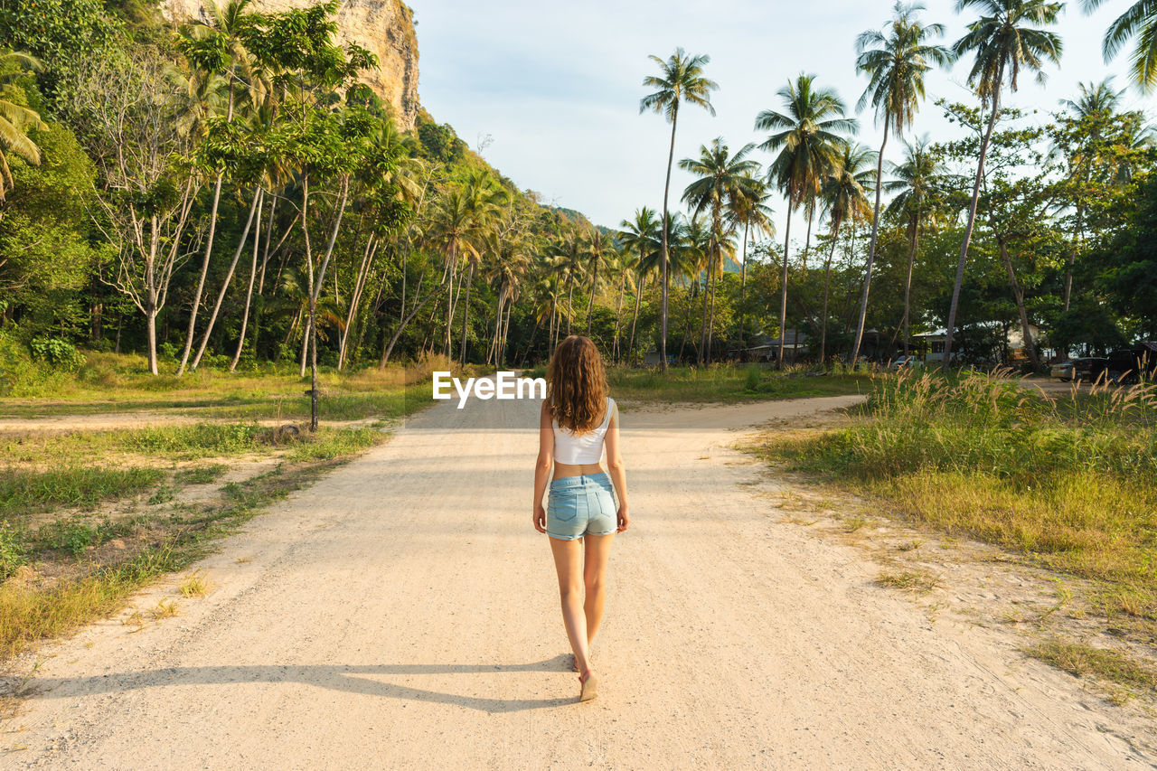 Rear view of woman walking on road