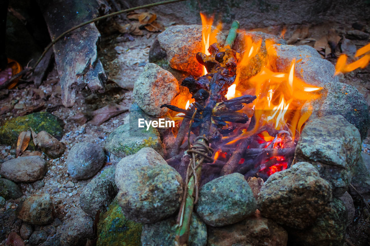 HIGH ANGLE VIEW OF BONFIRE ON ROCK