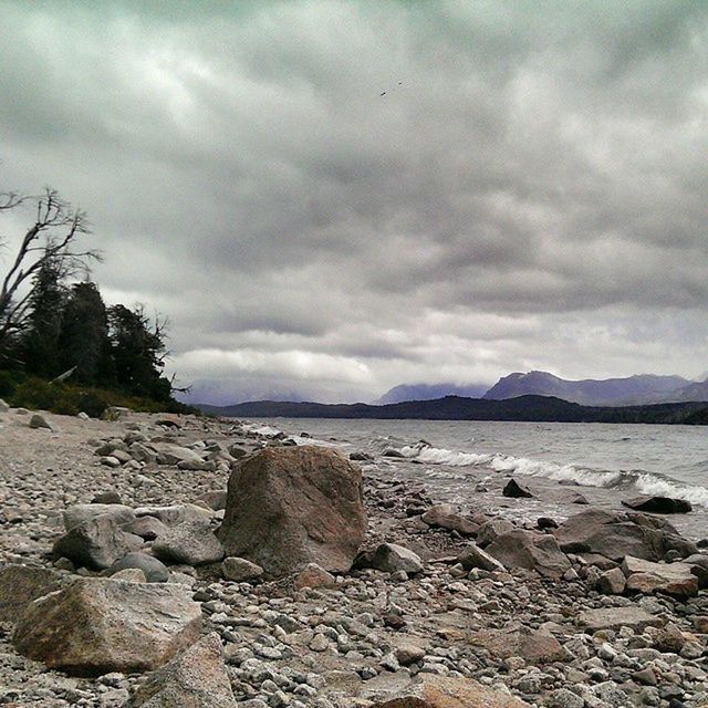 SCENIC VIEW OF SEA WITH MOUNTAIN IN BACKGROUND