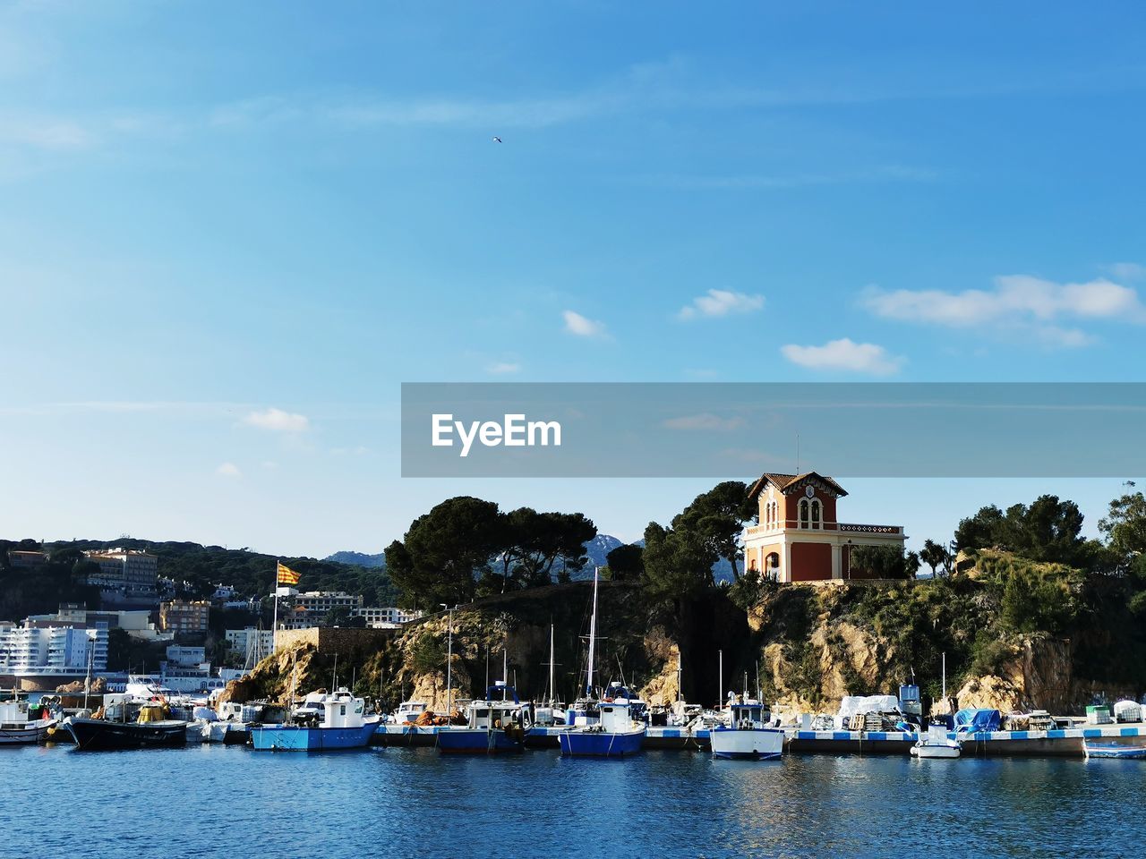 Boats in sea by buildings against sky