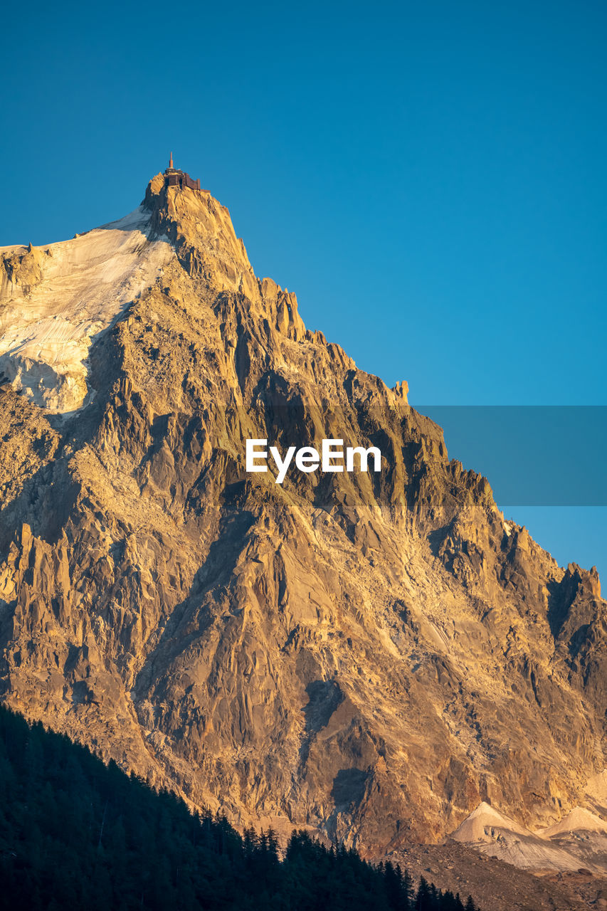 low angle view of rock formations against clear blue sky