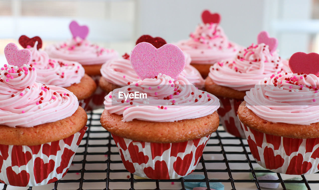 CLOSE-UP OF CUPCAKES ON TABLE AGAINST WALL