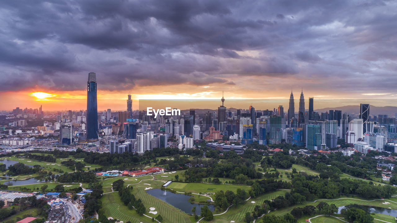 AERIAL VIEW OF BUILDINGS AGAINST CLOUDY SKY